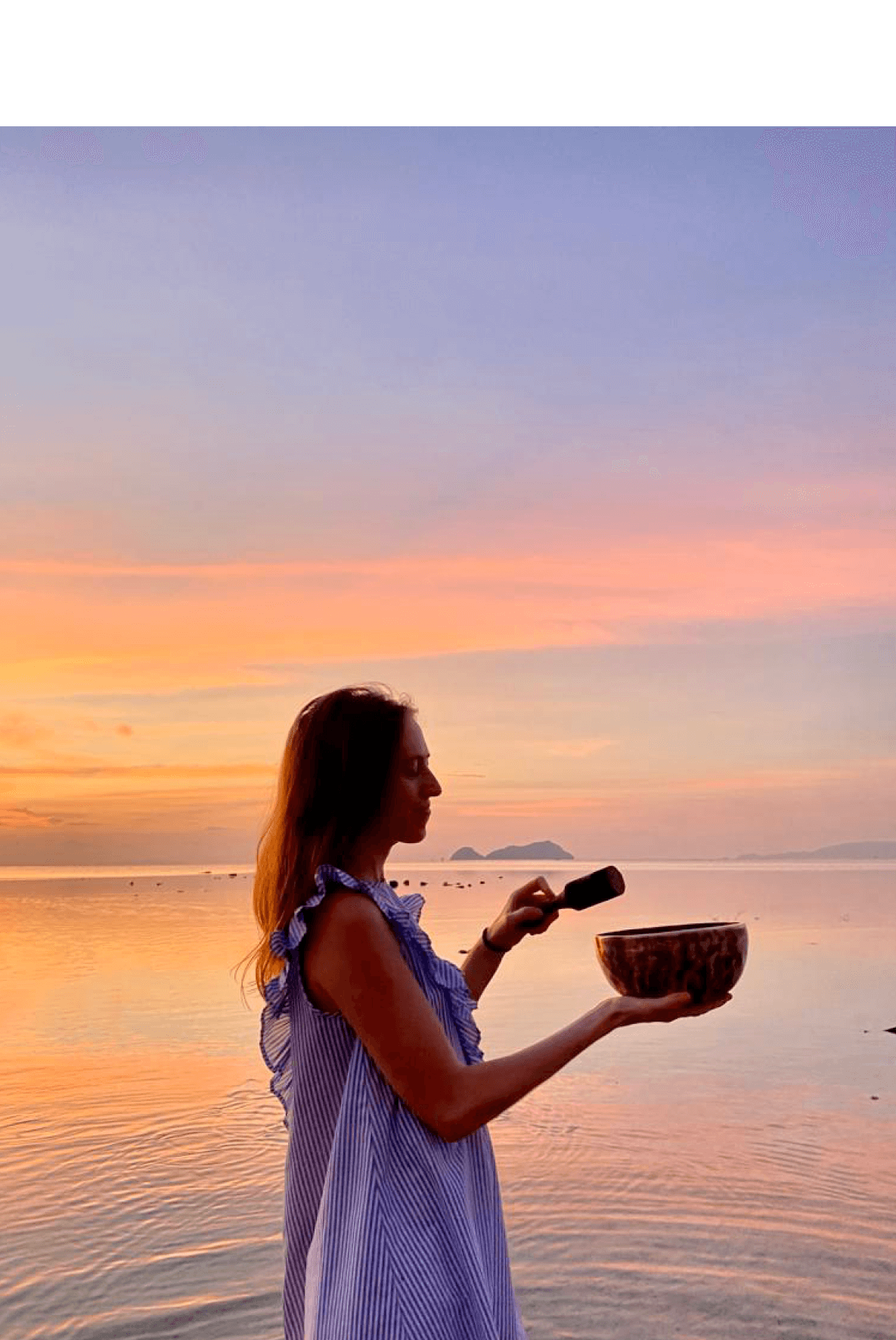 Pauline avec un bol tibétain devant un coucher de soleil